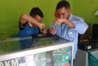 Tim Sahabat Komputer Borong saat memperbaiki laptop rusak. (Foto: Inong/GBRNews.id)