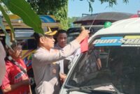 Kapolres Manggarai Timur, AKBP Haryanto, saat memasang bendera merah putih di sala satu mobil pickup warga. (Foto: Nardin Lonnista/ GBRNews.id)