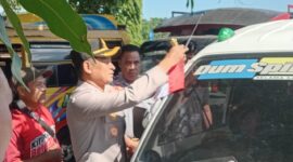 Kapolres Manggarai Timur, AKBP Haryanto, saat memasang bendera merah putih di sala satu mobil pickup warga. (Foto: Nardin Lonnista/ GBRNews.id)