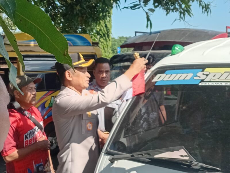 Kapolres Manggarai Timur, AKBP Haryanto, saat memasang bendera merah putih di sala satu mobil pickup warga. (Foto: Nardin Lonnista/ GBRNews.id)