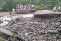 Beberapa warga setempat sedang memantau Jembatan Pina Rangkat lumpuh total setelah diguyur hujan deras. (Foto:ist)