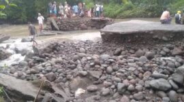 Beberapa warga setempat sedang memantau Jembatan Pina Rangkat lumpuh total setelah diguyur hujan deras. (Foto:ist)