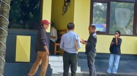 Haji Ramang Ishaka (topi merah) didampingi Kuasa hukumnya, Gabriel Kou (belakang), saat kembali masuk ke dalam ruang pemeriksaan Unit Tipidum Polres Mabar, Kamis (30/4/2026) siang. [Foto Rino/GBRNews.id]