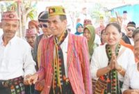 Cakades Golo Ndoal nomor urut 3, Roni Katu (tengah), didampingi istrinya, Fransiska Lidia, saat memasuki tenda kampanye akbar di Kampung Noa II, Jumat (25/9/2026). Foto: Rino/GBRNews.id